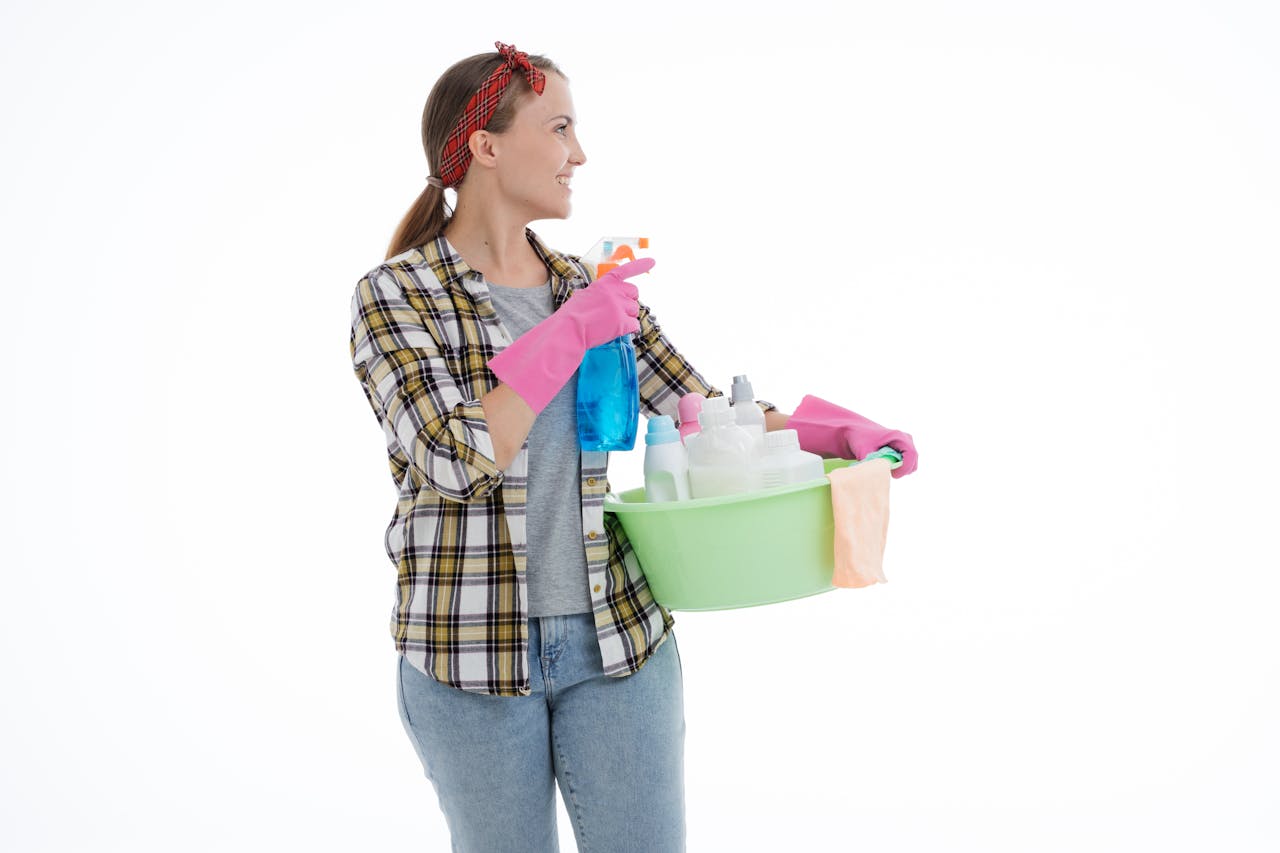 hero-img-02 Woman holding cleaning supplies in a studio shot with a white background. Perfect for housekeeping themes.
